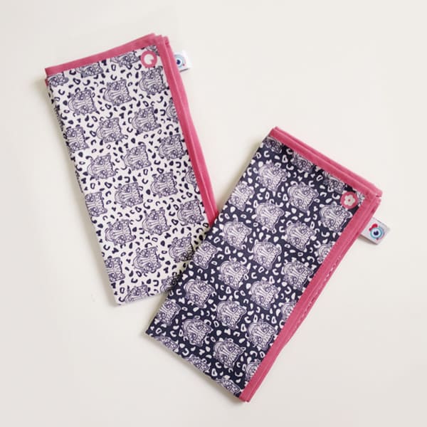 Lot de 2 serviettes de table en tissu, famille déco Grrr, motif léopard fond naturel et motif léopard fond bleu foncé. Bord rose